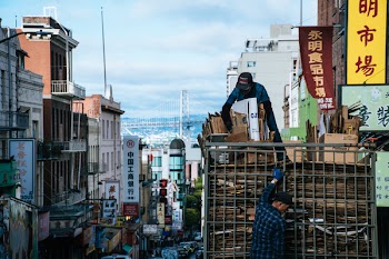 Man on Top of Truck Arranging Brown Cardboard Boxes
