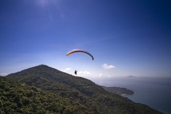 Man Paragliding Near Mountain