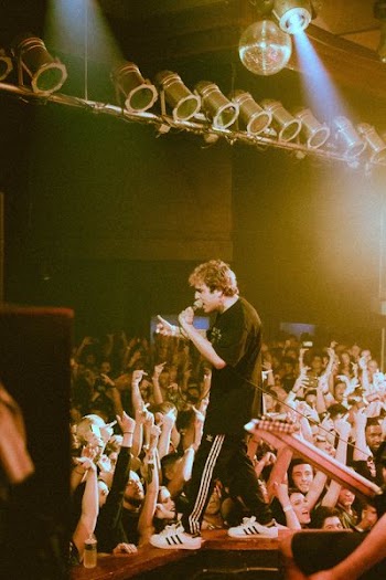 man performing on stage in front of crowd