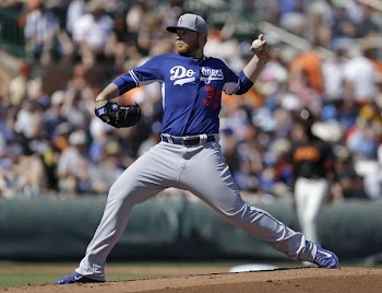 man pitching on the mound during daytime