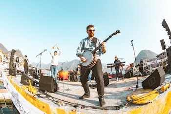 Man Playing Banjo Near Person Standing in Front of Microphone