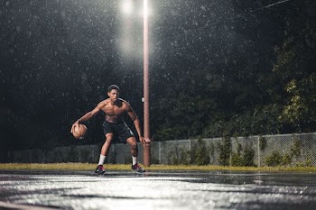 man playing basketball during nighttime