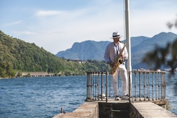 Man Playing French Horn on Dock