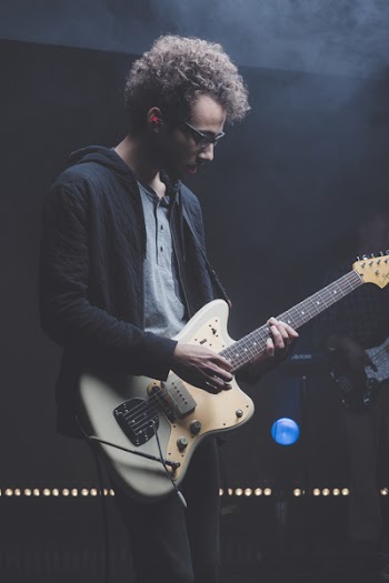 Man Playing Guitar While Looking Downwards