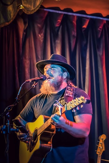 Man Playing Guitar While Singing