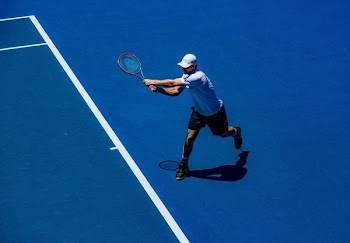 man playing tennis on field