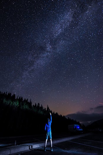 Man Pointing At The Sky Using His Right Index Finger At Night