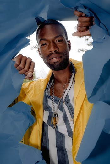 Man Posing Behind A Ripped Blue Paper
