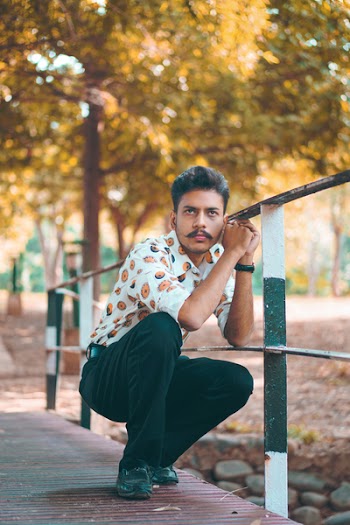 Man Posing Beside Metal Railing