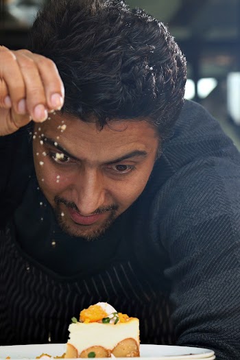 Man Pouring Condiment on Plate of Food