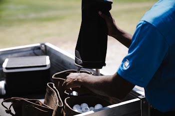 Man Pouring Golf Balls in Leather Bags