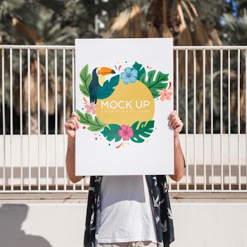 Man presenting poster mockup in front of park Free Psd