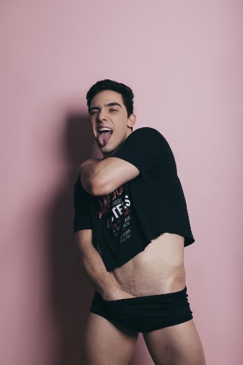 Man Putting Arm Backward While Standing Against Pink Wall