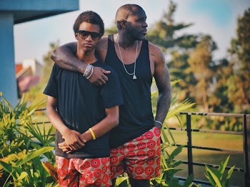 Man Putting His Shoulder Around Boy While His Other Hand Is Inside His Pocket