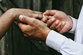 Man Putting Ring to Woman's Finger