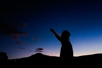 Man Raising His Right Hand and Mountains at the Distance