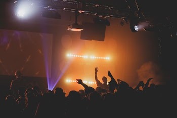 man raising right hand facing crowd