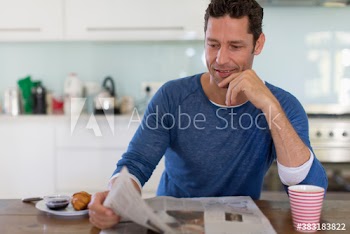 Man reading newspaper and enjoying breakfast