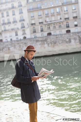 Man reading newspaper at River Seine, Paris, France