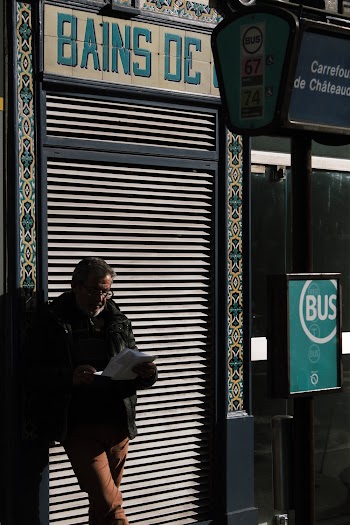 Man Reading Newspaper in Street