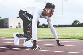 man ready to sprint on field track