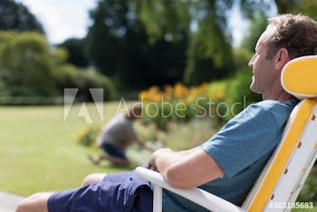 Man relaxing in lawn chair in sunny garden