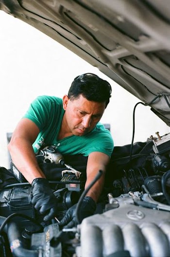 man repairing vehicle engine