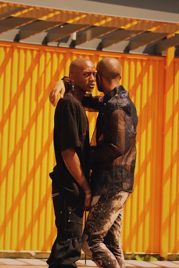man resting arm on other man's shoulder