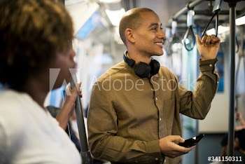 Man riding a train and holding his smartphone