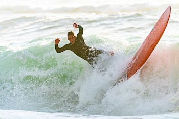 Man Riding a Wave on a Surfboard