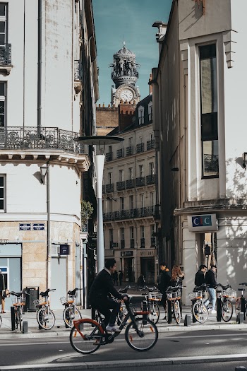 Man Riding Bicycle on Road Near Buildings