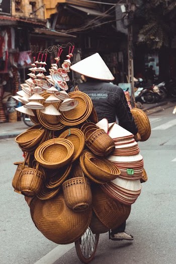 Man Riding Bicycle With Bowls And Baskets