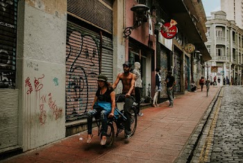 Man Riding Bicycle With Woman Sitting in Front