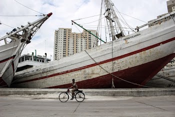 Man Riding Bike Beside Ship