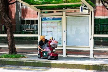 Man Riding  Electric  Wheel Chair Near Concrete Road