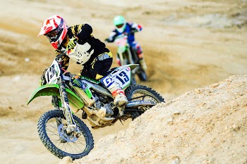Man Riding Motocross Dirt Bike on Terrain