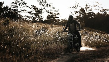 Man Riding Motorcycle on Brown Grass Field