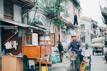man riding on bike in front of house