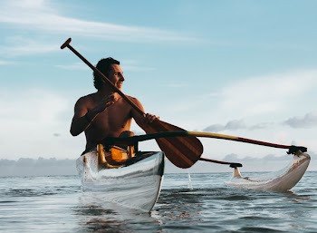 Man Riding on Boat Holding Brown Paddle