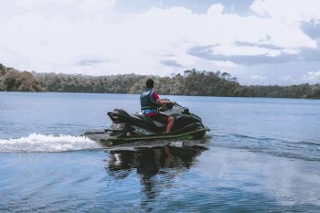 Man Riding on Green Personal Watercraft on Body of Water