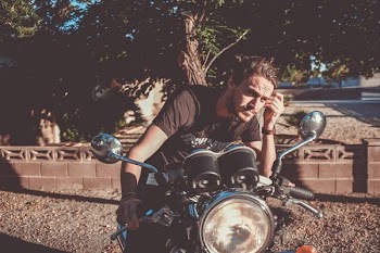 man riding on motorcycle looking at the mirror