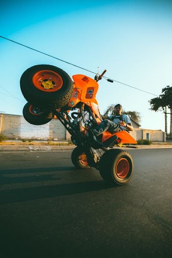 man riding on orange ATV