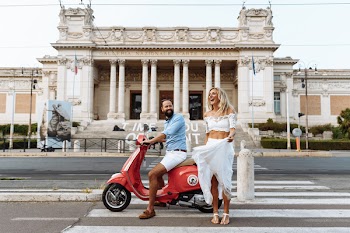 Man Riding on the Motorcycle Beside Woman Standing on the Road