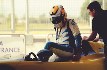 man riding on yellow sports car during daytime