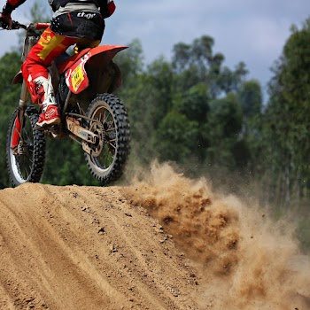Man riding red dirt bike on track