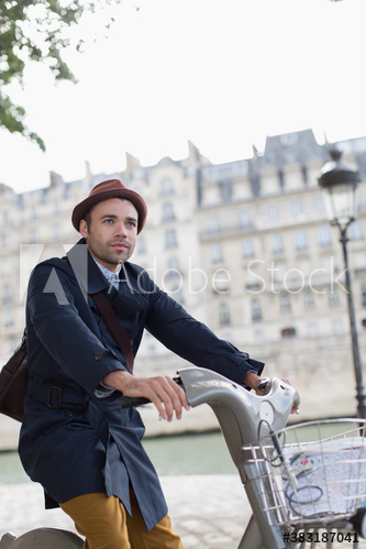 Man riding rented bicycle along Seine River, Paris, France