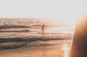 man riding skimboard during golden hour