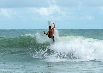 Man Riding Surfboard On Body Of Water