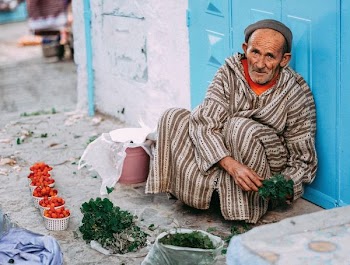man selling green leaf vegetable