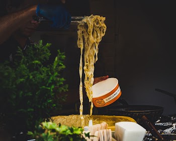 Man Serving Pasta on a Paper Cup
